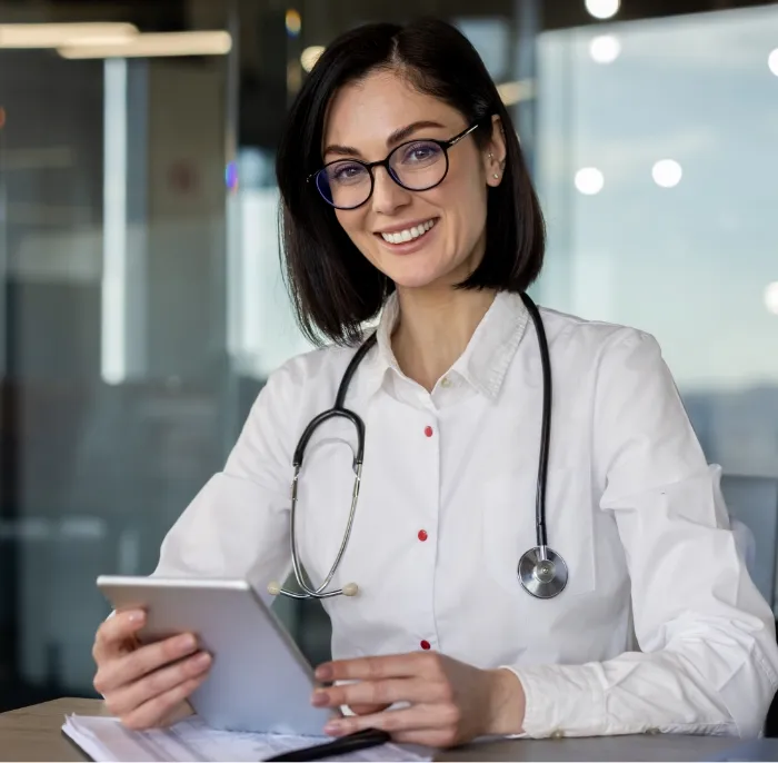 confident female doctor with stethoscope using tab utc
