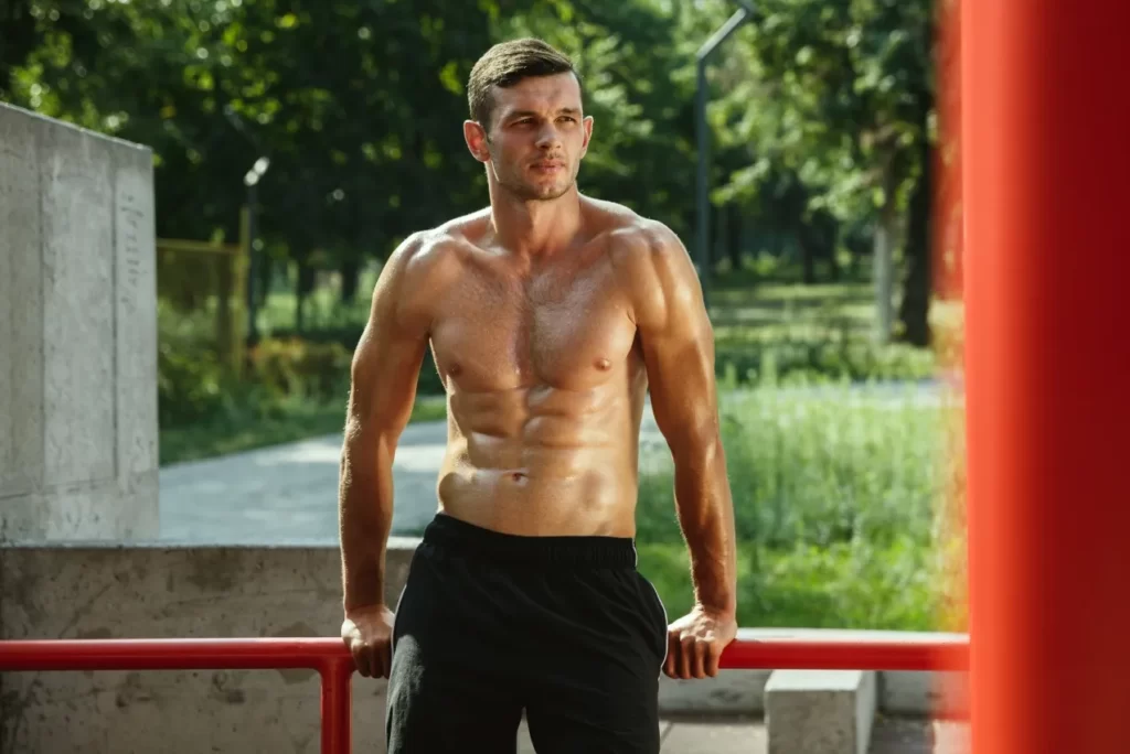 young muscular man while doing his workout outside utc